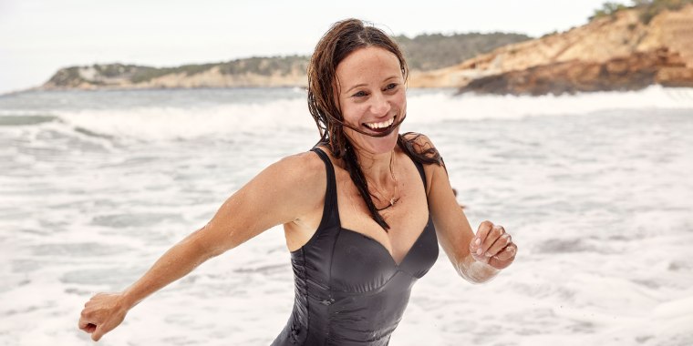 A female enjoying a fun brisk swim in the wild waves close to the shore,