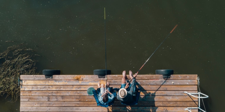 Family spending time together, Father and son fishing on jetty by the lake. Directly abov