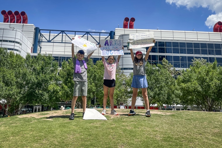 Travis Elementary students Jack DeHaven, Annie DeHaven, and Wren Fraske protest in front of the George R. Brown convention center while the annual NRA meeting is being help on May 27, 2022.