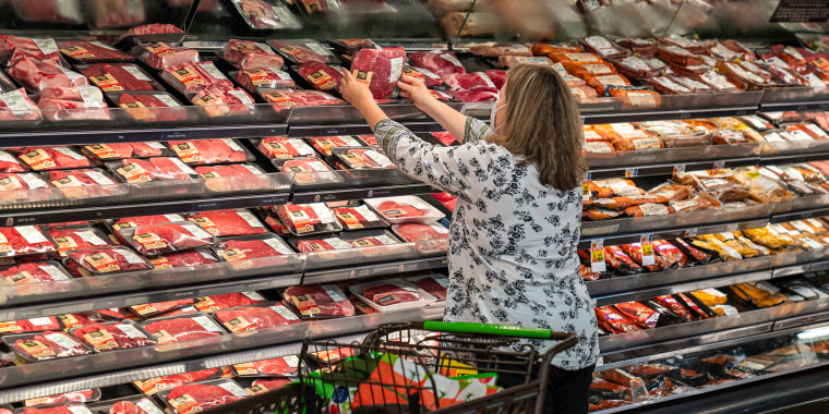 Image: A shopper in the meat section at a supermarket.