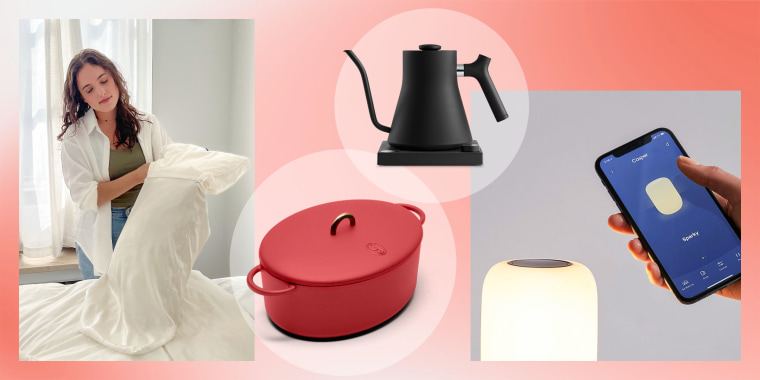Woman putting on a Blissy pillow case, Great Jones red dutch oven, Kettle and a Casper light glow