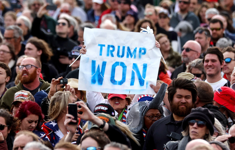 Image: A person in the crowd holding a sign that reads,\"Trump Won\".
