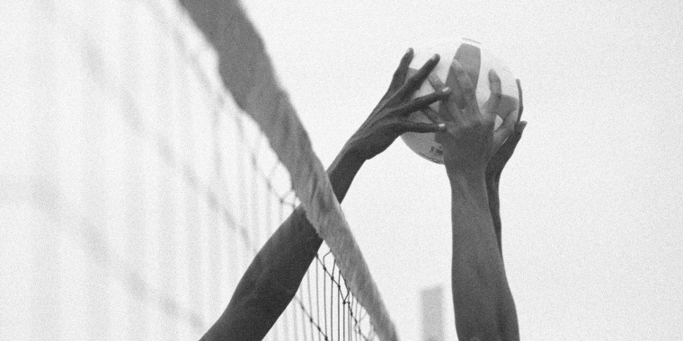 Image: Two hands trying to grab a volleyball.