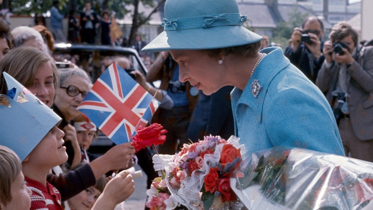 Image: Queen Elizabeth II talking to children in the crowd assembled to greet her.