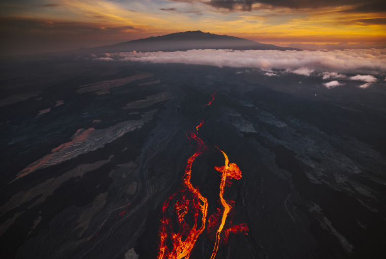 In an aerial view, lava fissures flow downslope from the north flank of Mauna Loa Volcano on December 7, 2022 in Hilo, Hawaii. For the first time in almost 40 years, the biggest active volcano in the world erupted prompting an emergency response on the Bi