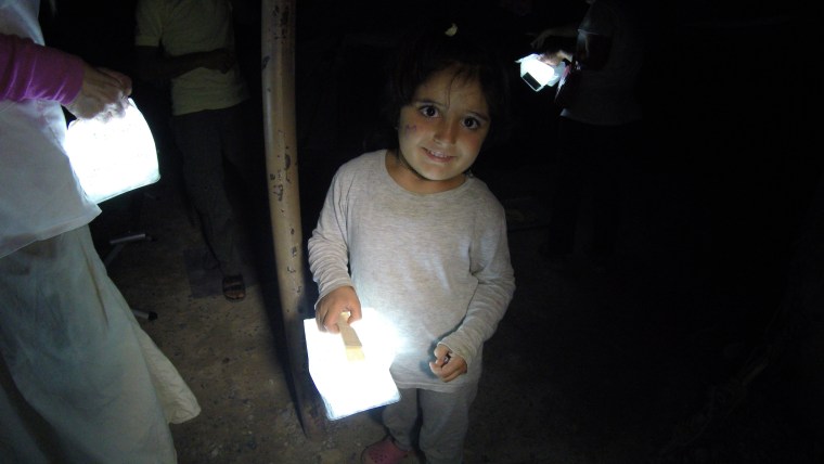 A Syrian refugee holding a Solight lantern.