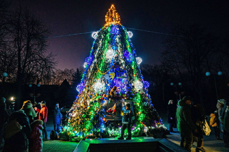 A Christmas tree made of camouflage nets draws a small crowd in Mykolaiv, Ukraine, on Dec.19, 2022.