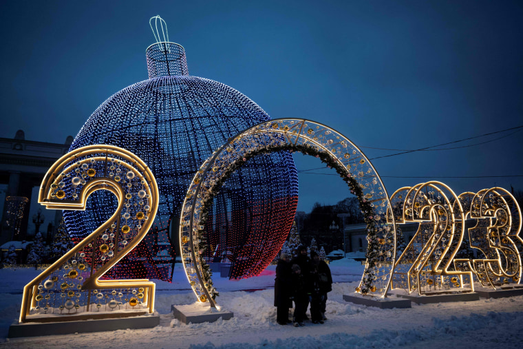 A family poses in front of Christmas and New Year decorations in Moscow on Dec. 19, 2022.