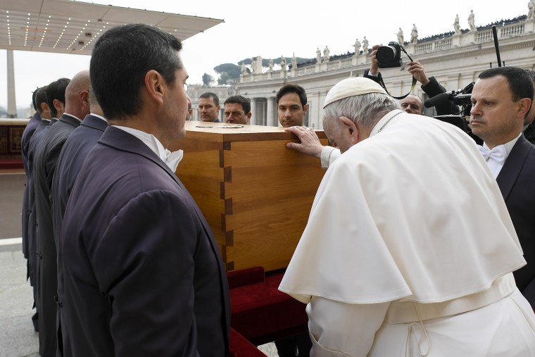 Pope Francis touches the coffin of late Pope Emeritus Benedict XVI after his funeral mass in St. Peter's Square at the Vatican, Thursday, Jan. 5, 2023.