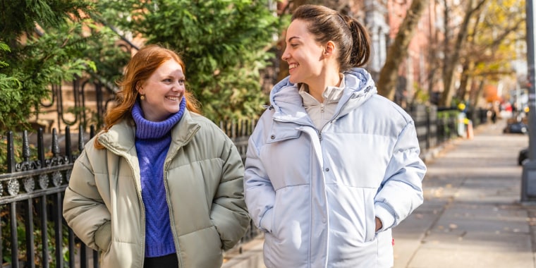 Two woman wearing puffer jackets outside