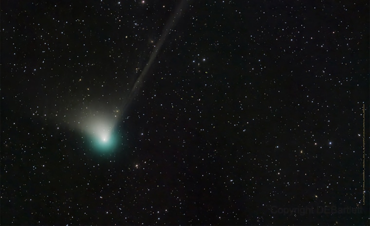 A distant image of a green comet with its streaking tail of dust that visible in the night sky on Wednesday, February 1 as it passed overhead at 128,000 miles per hour some 26 million miles from Earth.