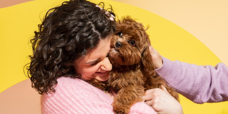 A Woman hugging a brown dog