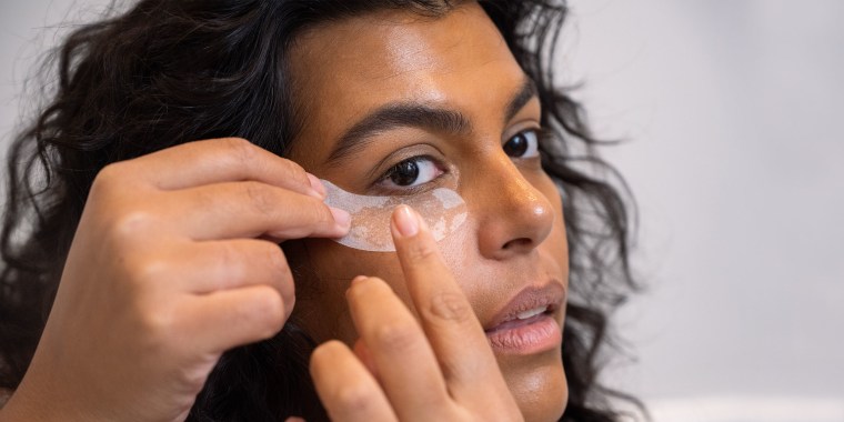 Woman putting on under eye patch