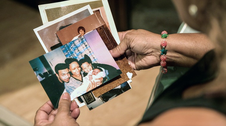 Maria Velazquez holds a stack of family photos in her hands. One of the photos shows her son, JJ Velazquez, smiling with his then-girlfriend, Vanessa Cepero, and their two sons.
