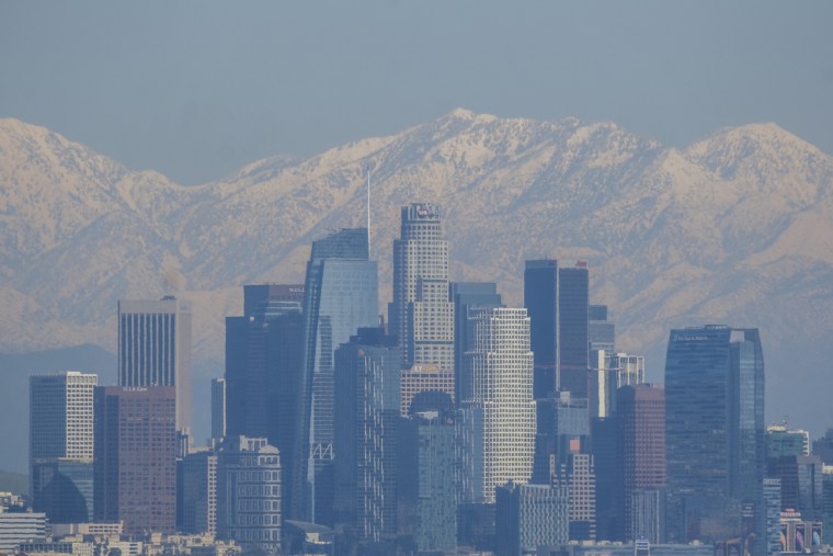 After a rare snowstorm in Southern California, snow covered the San Gabriel mountain range are seen behind downtown Los Angeles skyline.