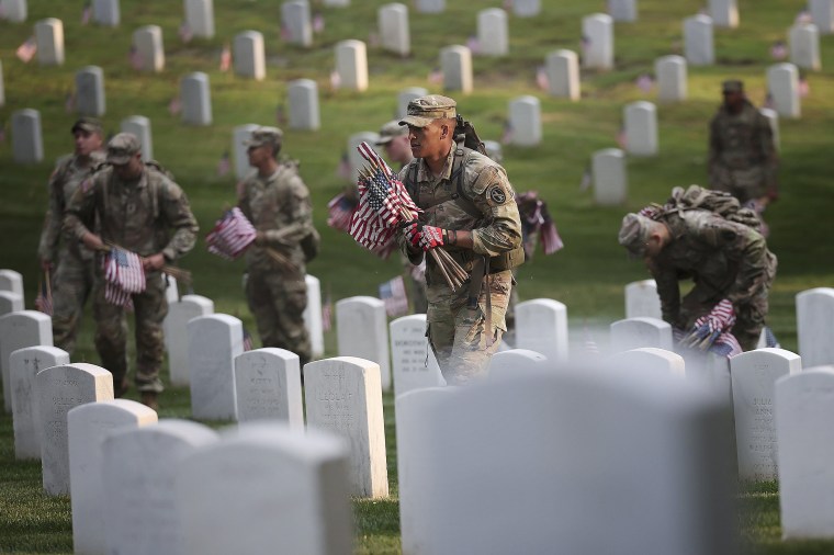 Members of the 3rd U.S. Infantry Regiment place flags at the headstones of U.S. military personnel buried at Arlington National Cemetery, in preparation for Memorial Day, on May 25, 2023 in Arlington, Virginia. More than 1000 service members entered the c