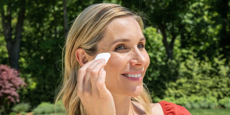 Woman using a sunscreen stick on her face