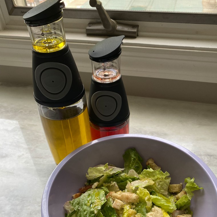 Olive Oil and Vinegar Dispenser Set in front of a salad