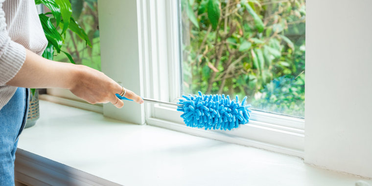 Hand dusting a window sill