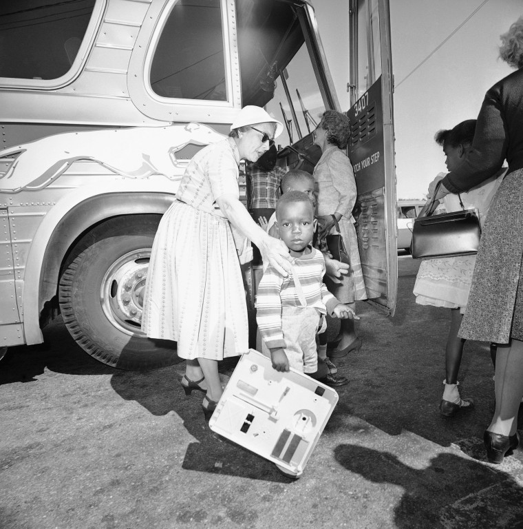 Two unidentified women, residents of Hyannis, Mass., help some of the nine children of Lela Mae Williams (not in photo) off the bus, June 8, 1962