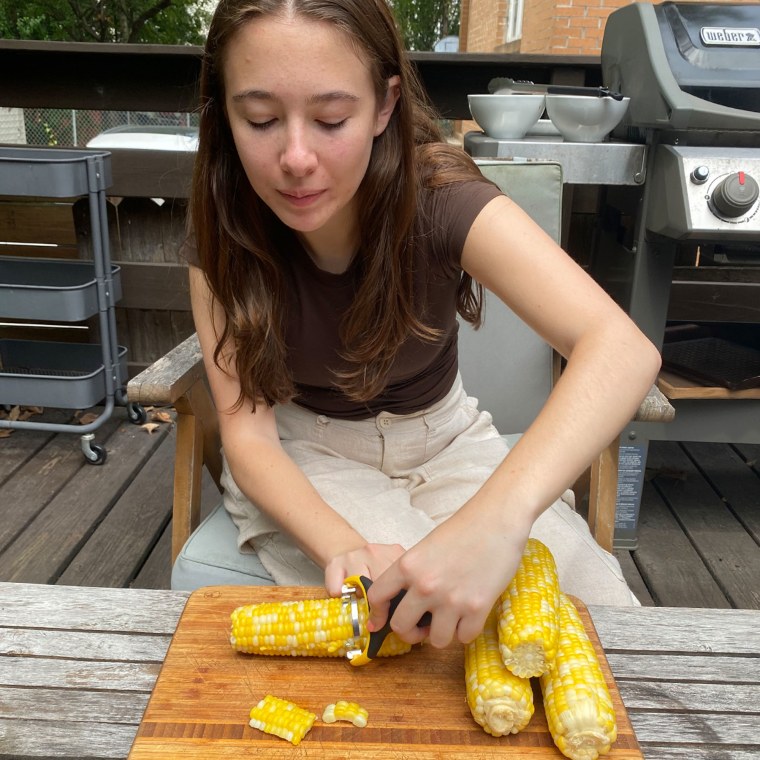 Woman sitting peeling corn