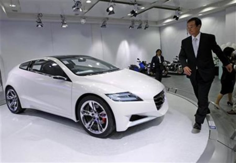 Honda Motor Co's chief executive Takanobu Ito walks past a CR-Z car at a showroom in Tokyo