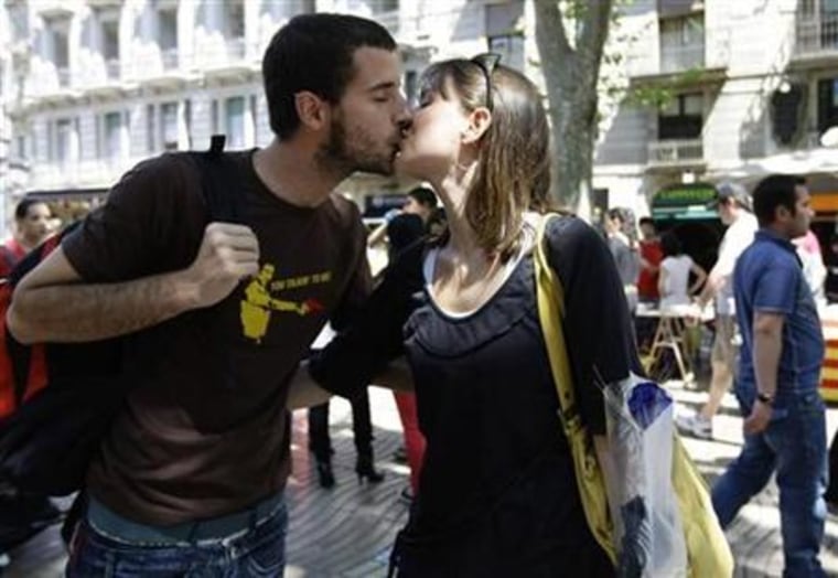 A couple kiss along Las Ramblas street during traditional Sant Jordi's day celebrations in Barcelona