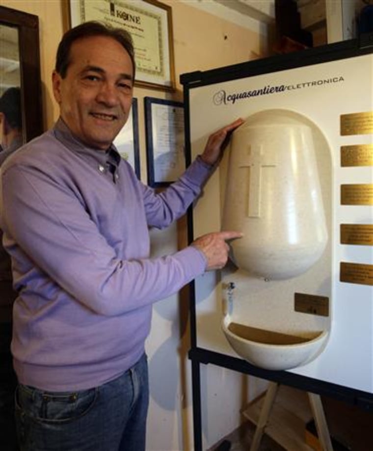 Inventor Marabese displays a prototype of his holy water dispenser at his office in Capriano Briosco