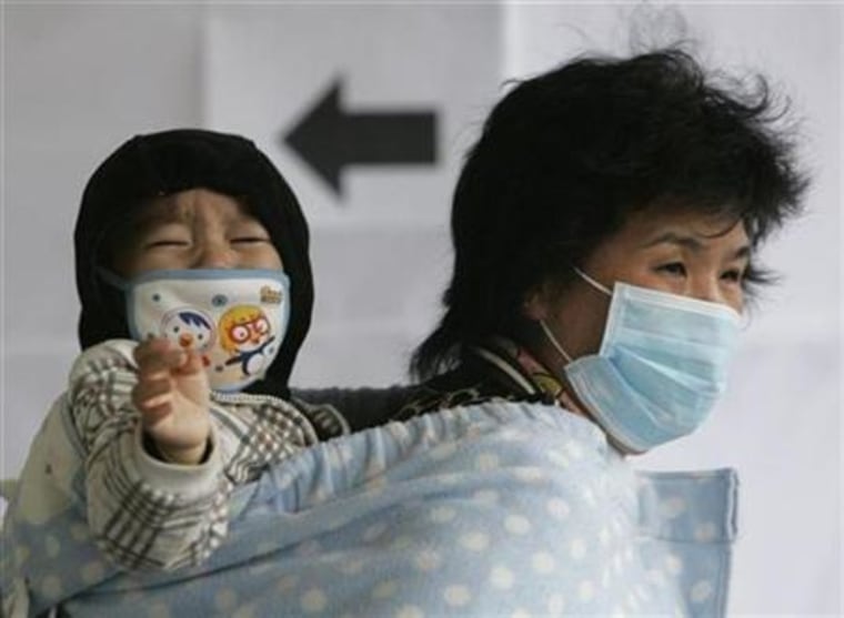 A woman and a child wear masks as they wait for a H1N1 flu check-up at a temporary H1N1 flu treatment centre at a hospital in Seoul