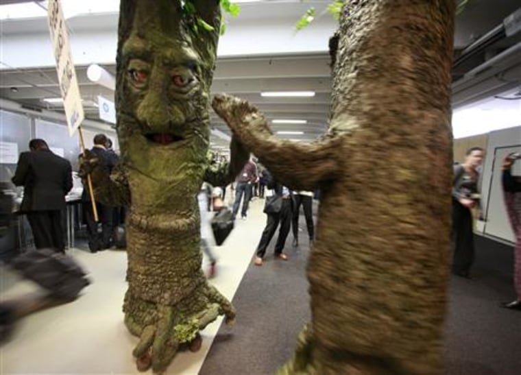 Activists from Avaaz.org dressed as trees hold an event in the main hall of the Bella Center during the Copenhagen Climate Change Conference 2009 in Copenhagen