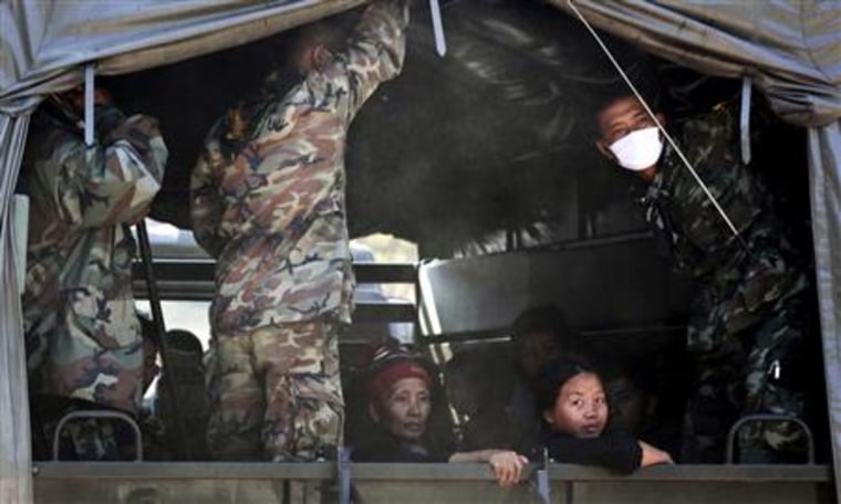 The first batch of ethnic Hmong people are guarded by the military on a truck on the way out of the Ban Huay Nam Khao camp to the border with Laos, in Phetchabun province