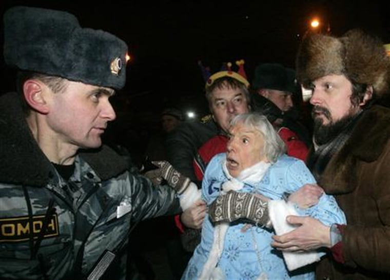 A police officer detains human rights activist and Moscow Helsinki group chairperson Alekseyeva dressed as Snow Maiden during an unauthorised demonstration in central Moscow