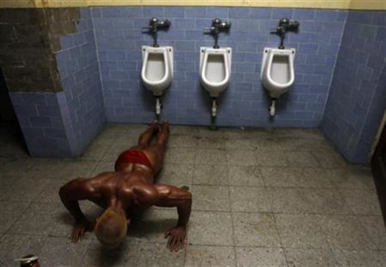 A competitor trains inside a bathroom before a bodybuilding competition in Lima