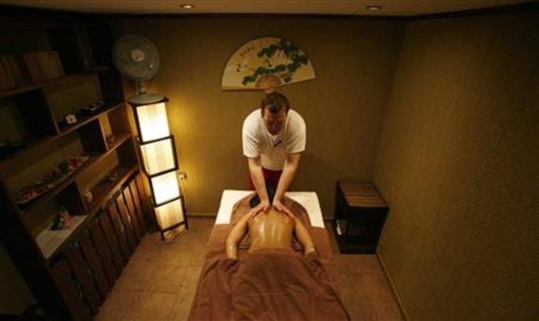 A masseur gives a woman a massage at a spa centre of a hotel in the town of Velingrad, central Bulgaria