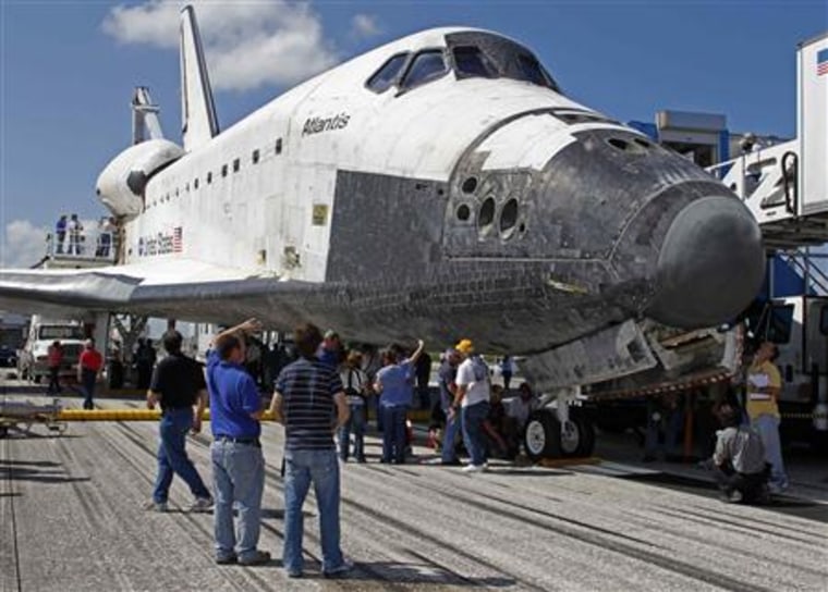 NASA technicians work on the space shuttle Atlantis after it landed in Cape Canaveral