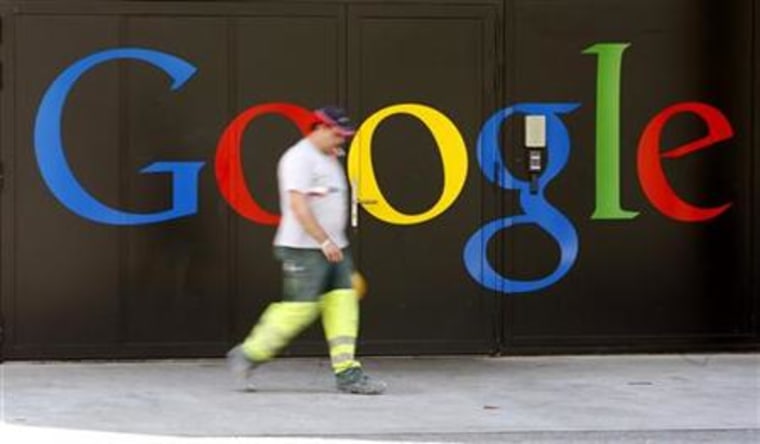 A construction worker walks past a logo next to the main entrance of the Google building in Zurich
