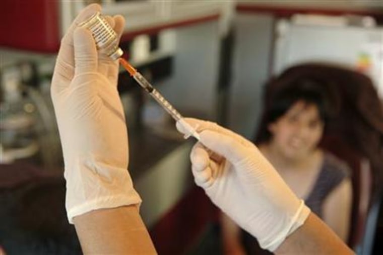 A health worker prepares H1N1 flu vaccine at a camp in Penco town