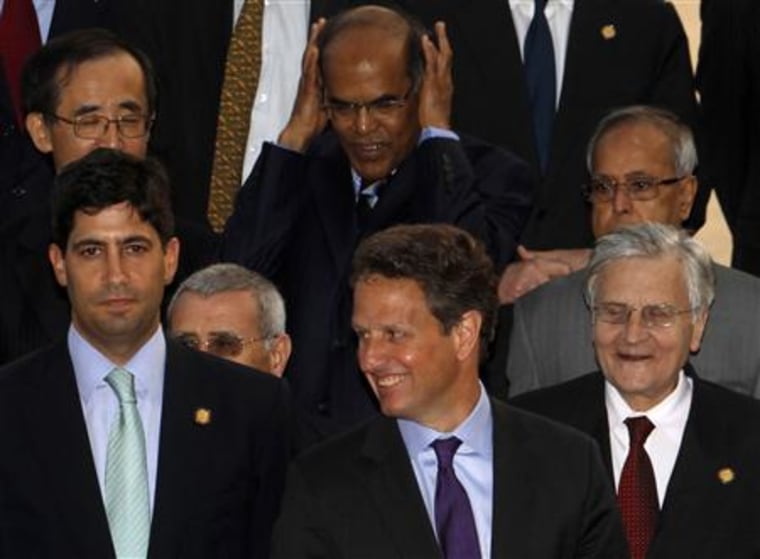 U.S. Treasury Secretary Geithner smiles beside U.S. Federal Reserve Governor Warsh during a group photograph in Busan
