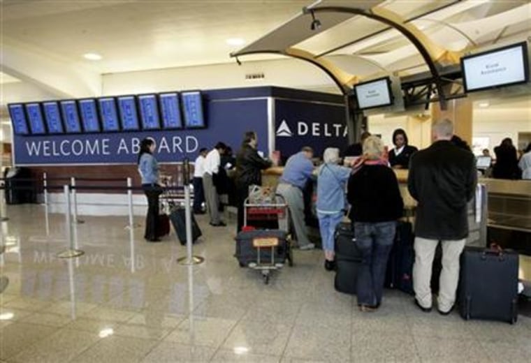 Passengers check in at a Delta Airlines ticket counter at Hartsfield-Jackson Atlanta International Airport