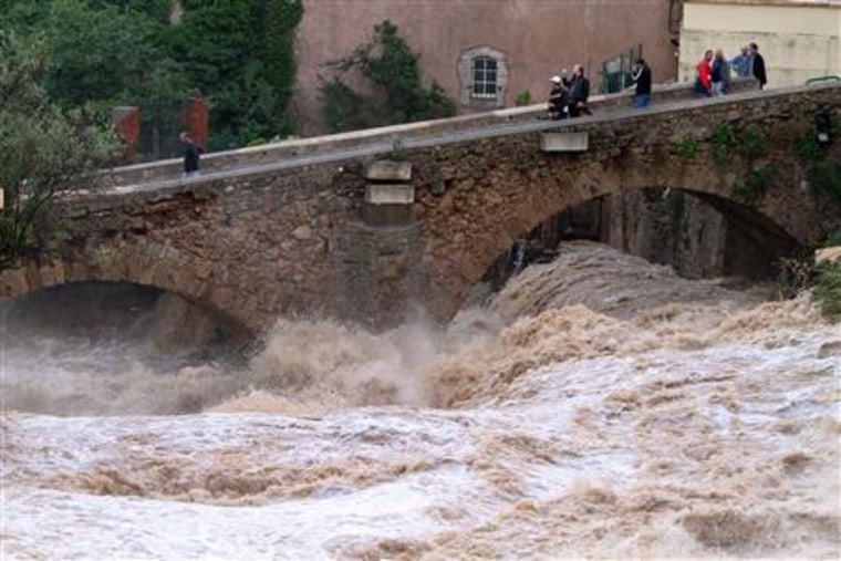 People look at La Nartuby river at a bridge crossing after heavy flooding in Trans en Provence