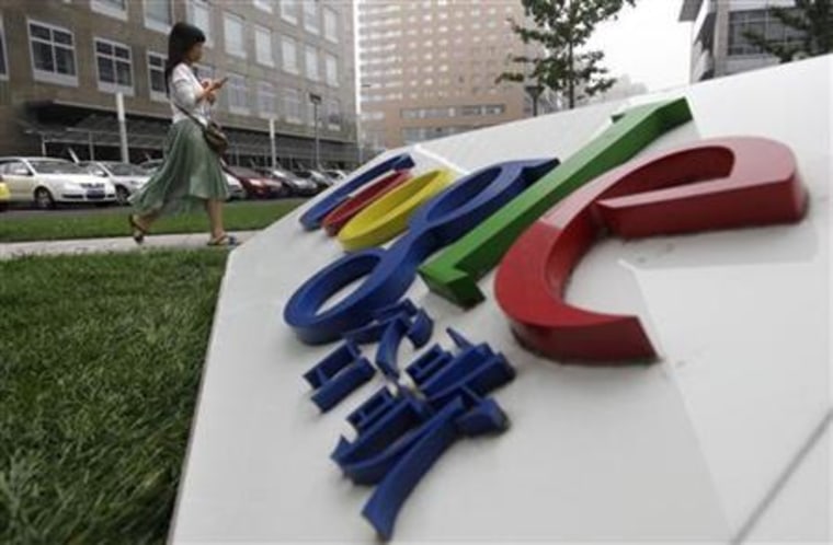 An employee walks past the logo of Google in Beijing
