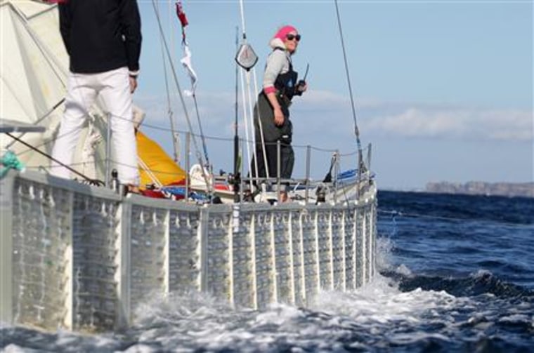 Crew member Royle watches from the deck of 60-foot-long Plastiki catamaran as it is towed through Sydney Harbour