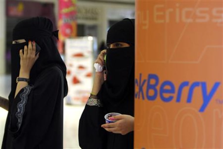 Veiled Saudi women talk on their BlackBerry phones at a shopping mall in Riyadh