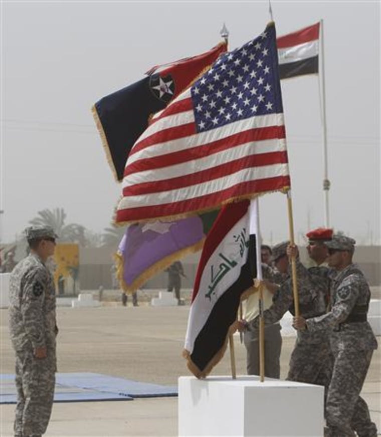 U.S. soldiers from the 4th Stryker Brigade 2nd Infantry Division carry flags during a ceremony in Baghdad