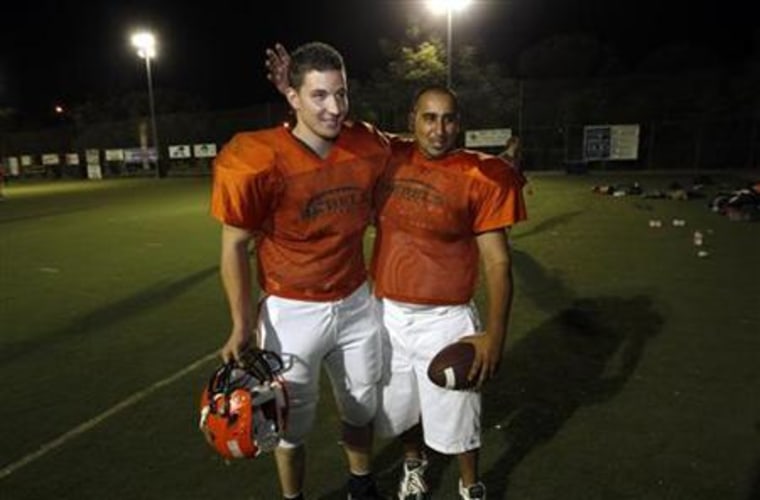Palestinians Musa Elayyan (L) and his cousin Ramzi Ahmed, both members of the Judean Rebels amateur football team, stand together during a team practice at a stadium in Jerusalem August 19, 2010.