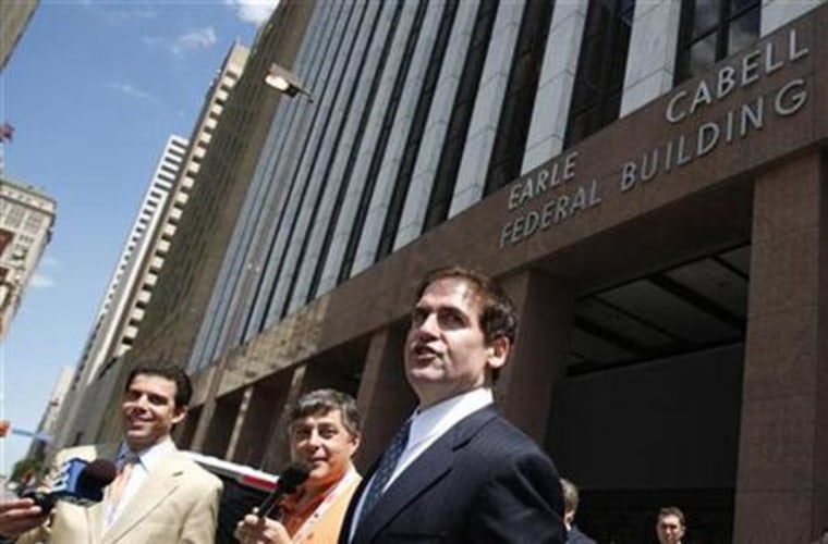 Dallas Mavericks team owner Mark Cuban jokes with reporters as he leaves the Earle Cabell Federal Court building