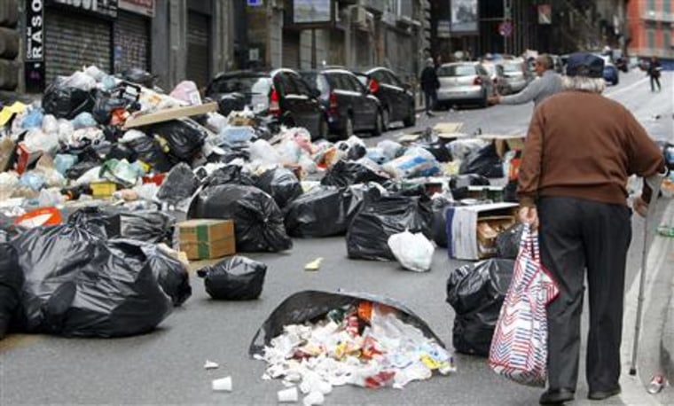 A man walks on a street full of rubbish in Naples