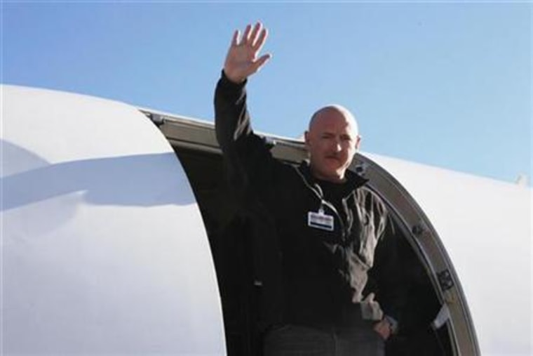 Handout shows NASA Shuttle Commander Kelly waving from a medical transport plane bound for Houston, after his wife was carried aboard in Tucson, Arizona