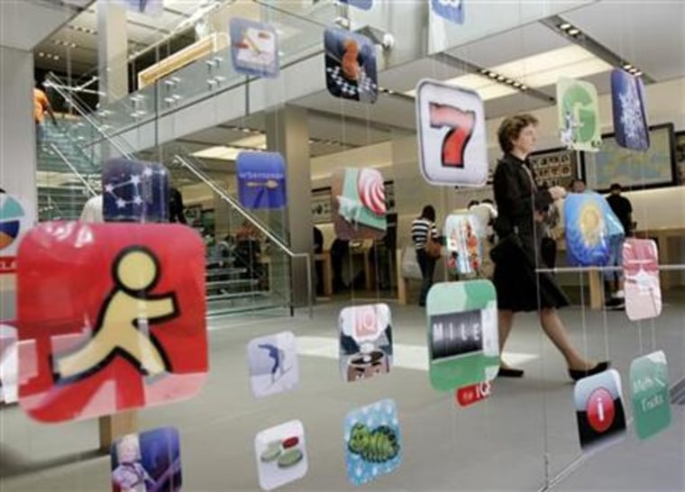 A woman walks past icons for Apple applications at the company's retail store in San Francisco, California in this April 22, 2009 file photo.