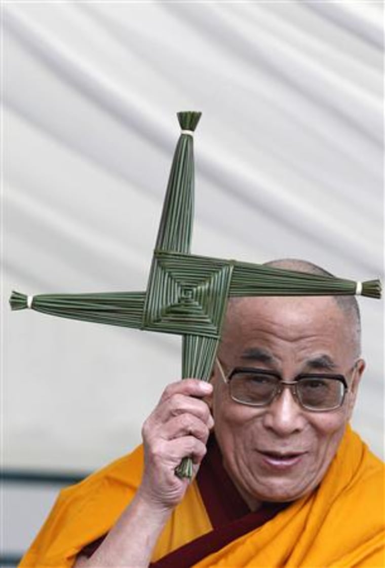 Tibet's exiled spiritual leader, the Dalai Lama, holds a gift of a St Brigid's cross during his visit to St Brigid's Church in Kildare, Ireland
